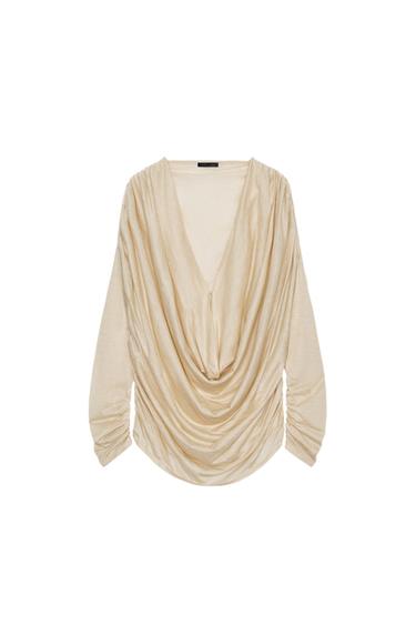 Front view of a top with a pronounced cowl neck and long, gathered sleeves. Hook and eye detail at the front.