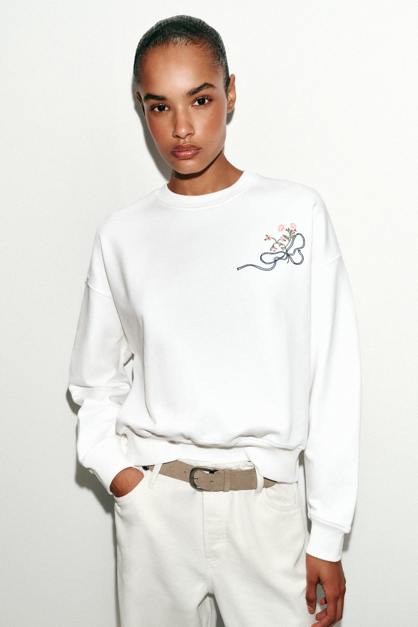 Sudadera blanca casual de Zara con bordado floral en el pecho.