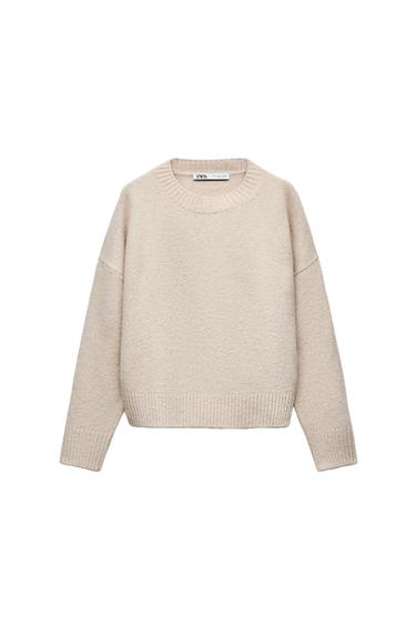 Front view of a beige jumper with a crew neck and ribbed cuffs.