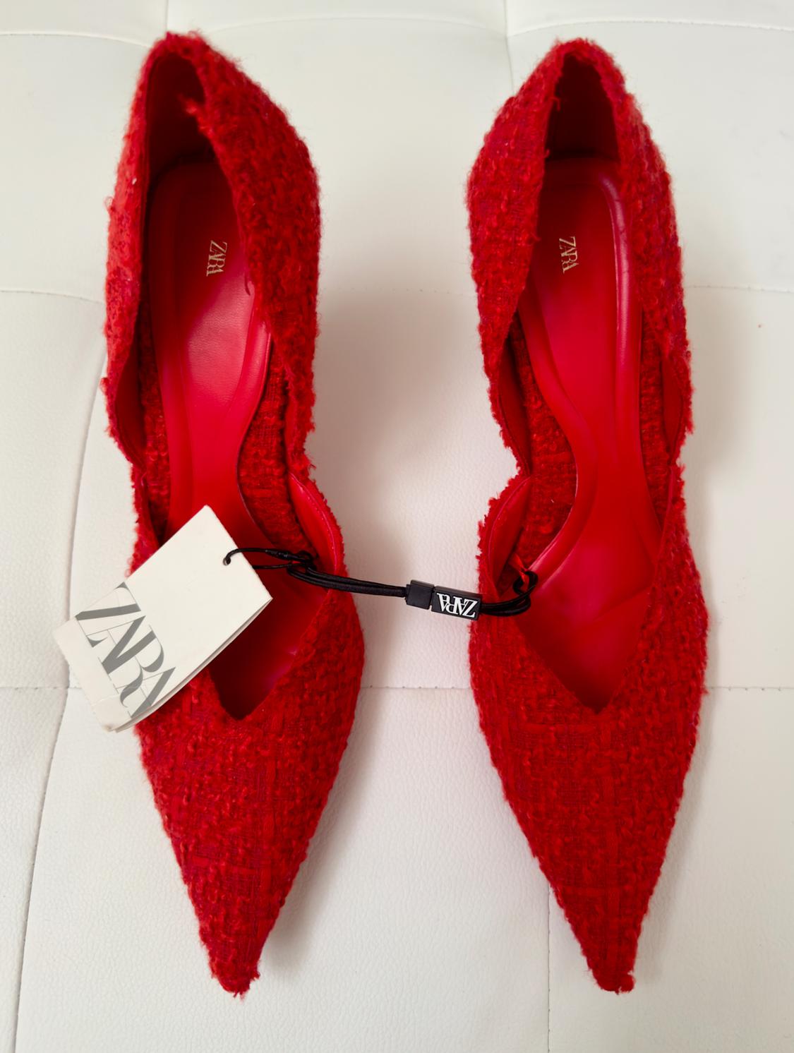 Red textured pointed shoes on a white background, visible label with the text "ZARA".