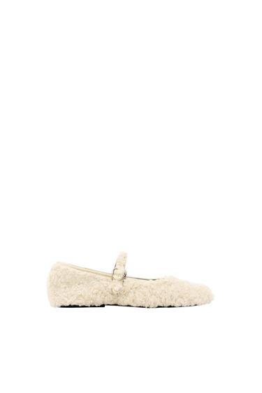 Women's beige furry textured flat shoe with strap, on a white background.