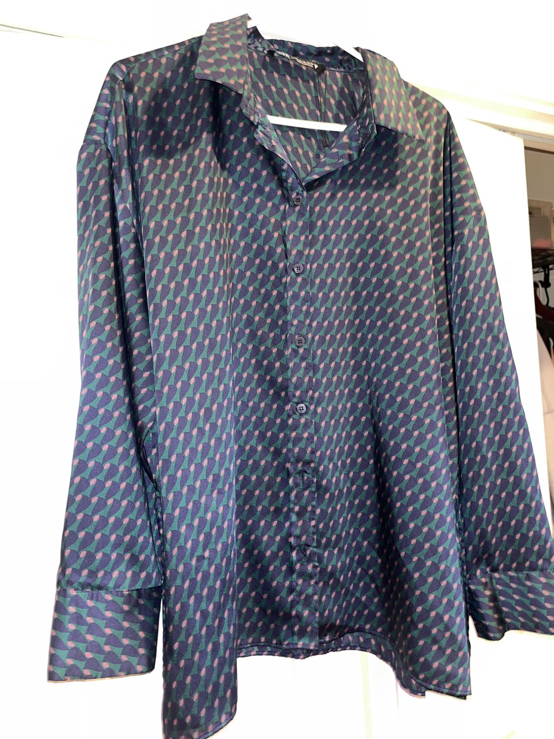 Hung satin shirt, with a geometric print in blue and green tones, white background.