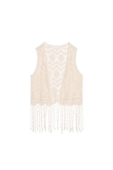 Front view of a beige waistcoat with tassels and openwork design.