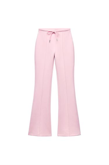 Front view of pink trousers with drawstring and visible seams.