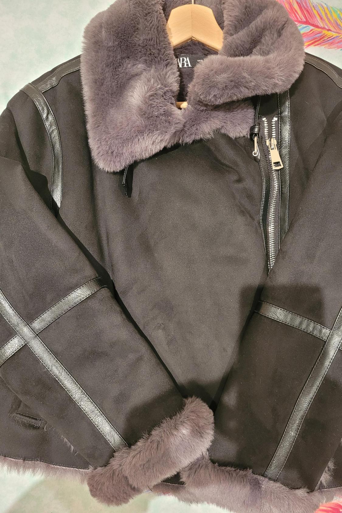 Detail of black jacket with zip and grey fur collar