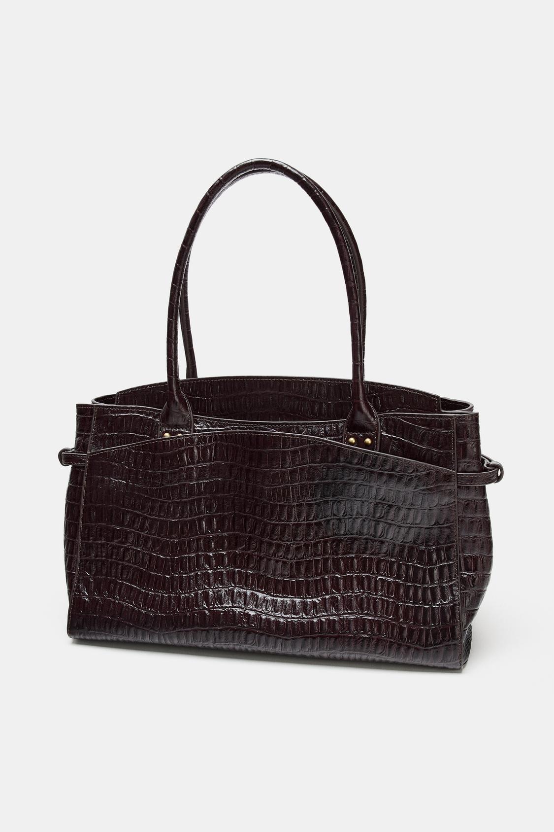 Dark brown handbag with crocodile texture, long handles and structured design.
