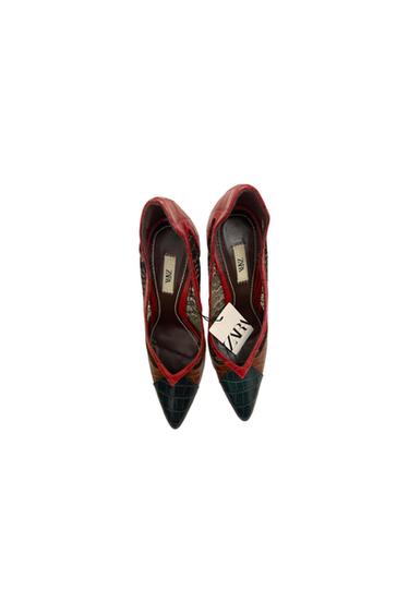 High-heeled shoes in red, green, and brown tones with a crocodile texture. Visible label with the text "ZARA".
