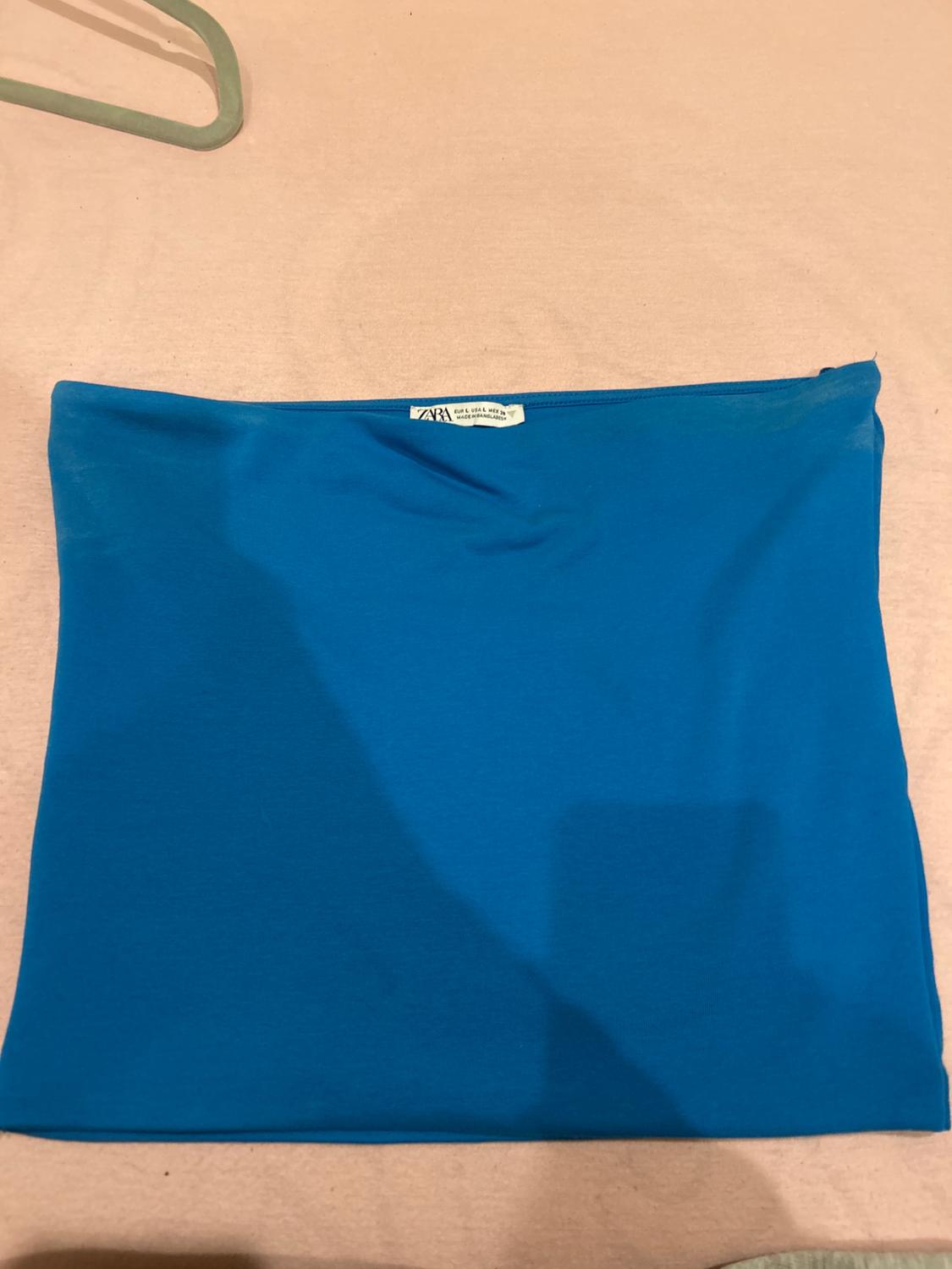 Front view of a blue skirt with a visible label at the top.