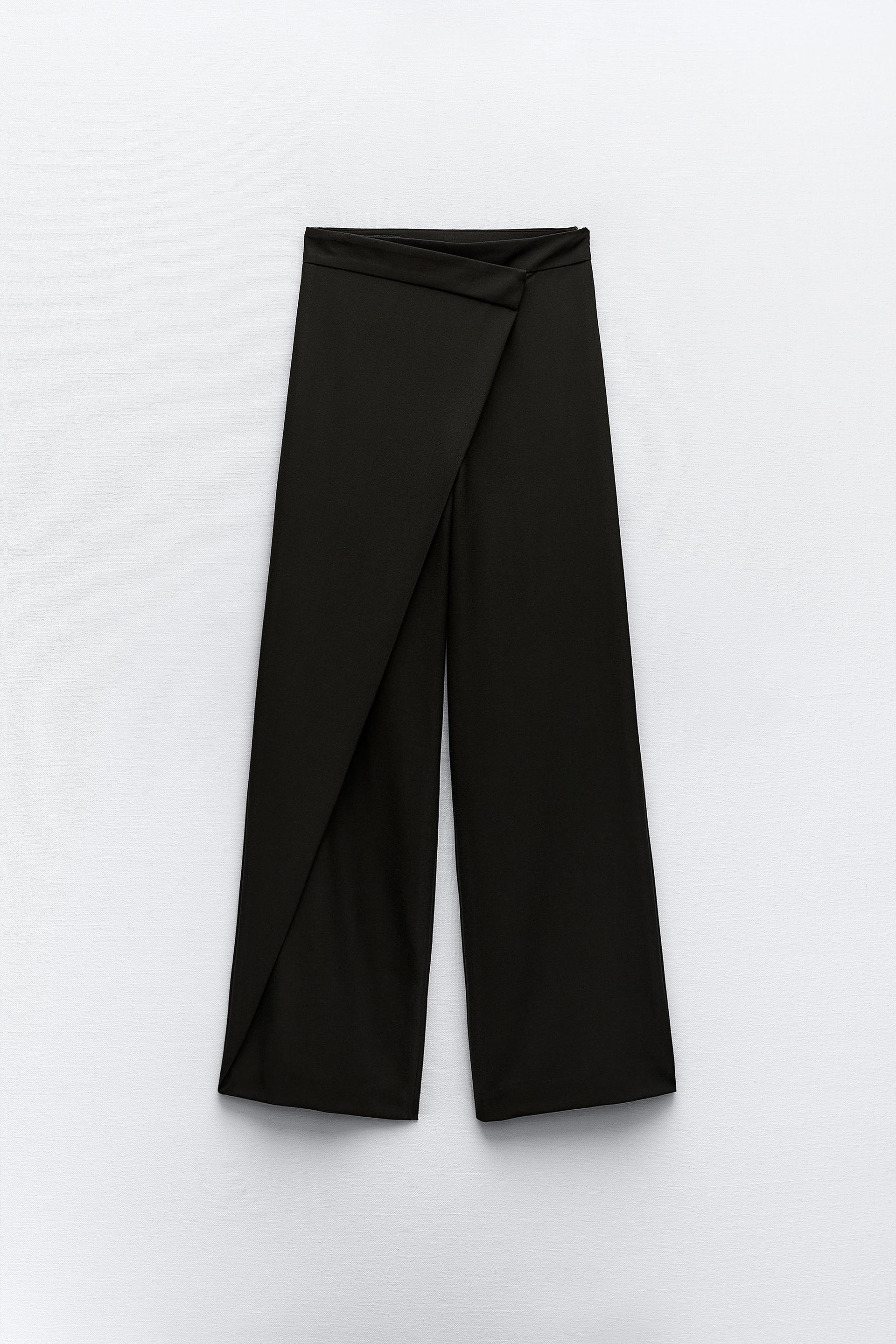 Pants with a high front wrap waist and snap button. Wide leg. Side hidden  in-seam zip closure.