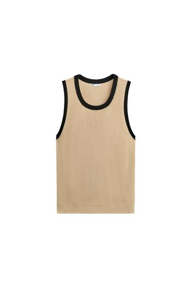 Front view of a beige waistcoat with black trim on the neck and armholes