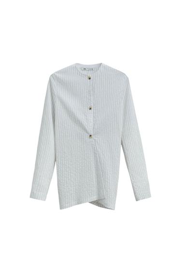 White shirt with fine vertical stripes, a grandad collar, and front buttons. Long sleeves and a straight cut. White background.