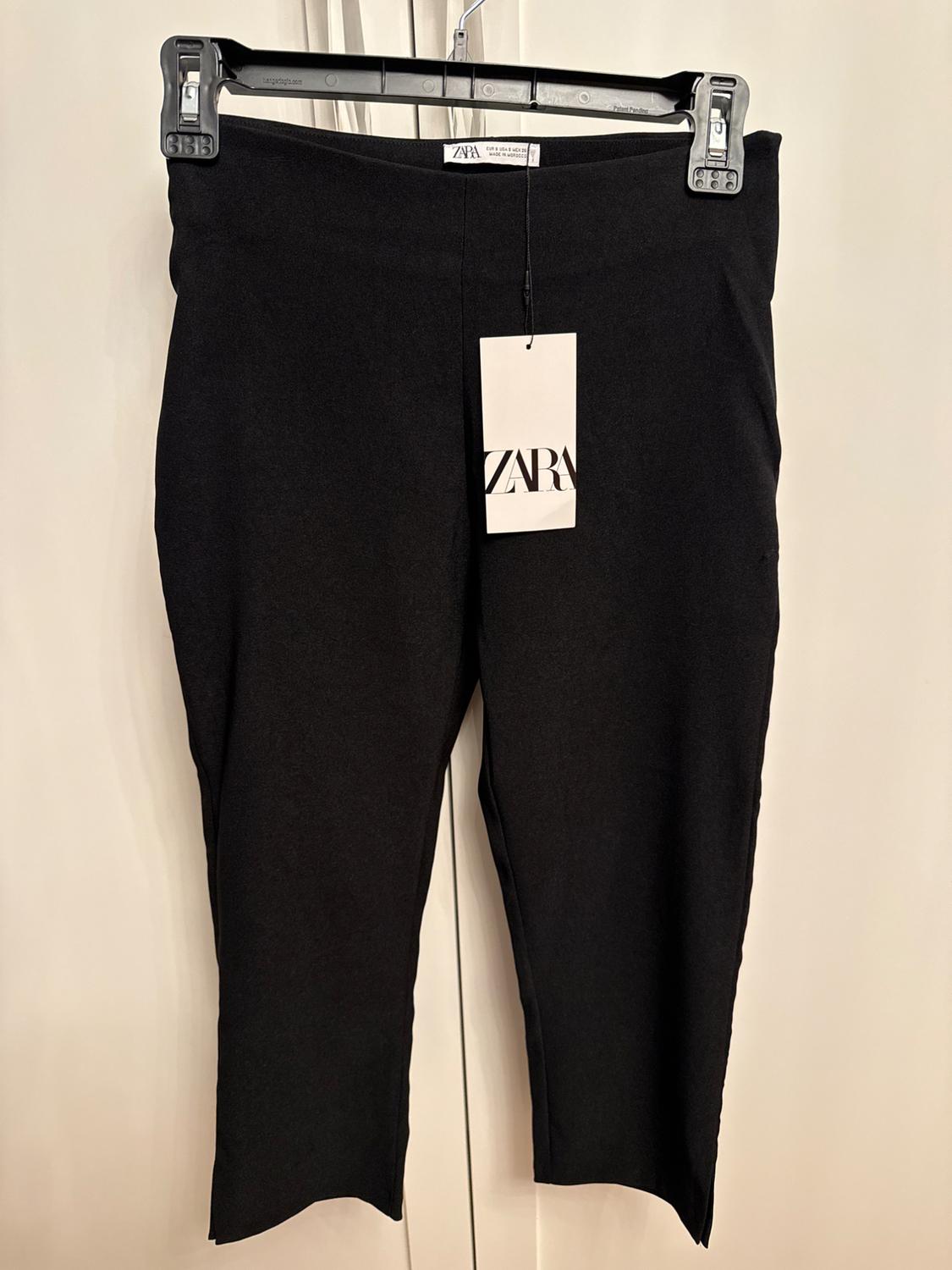 Front view of black trousers with visible 'ZARA' label.