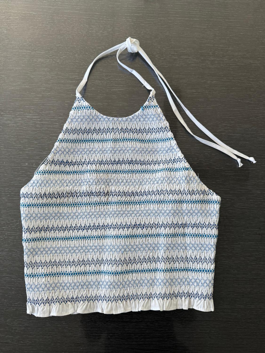 White halter top with blue and black line print on a dark background. Knot detail at the top.