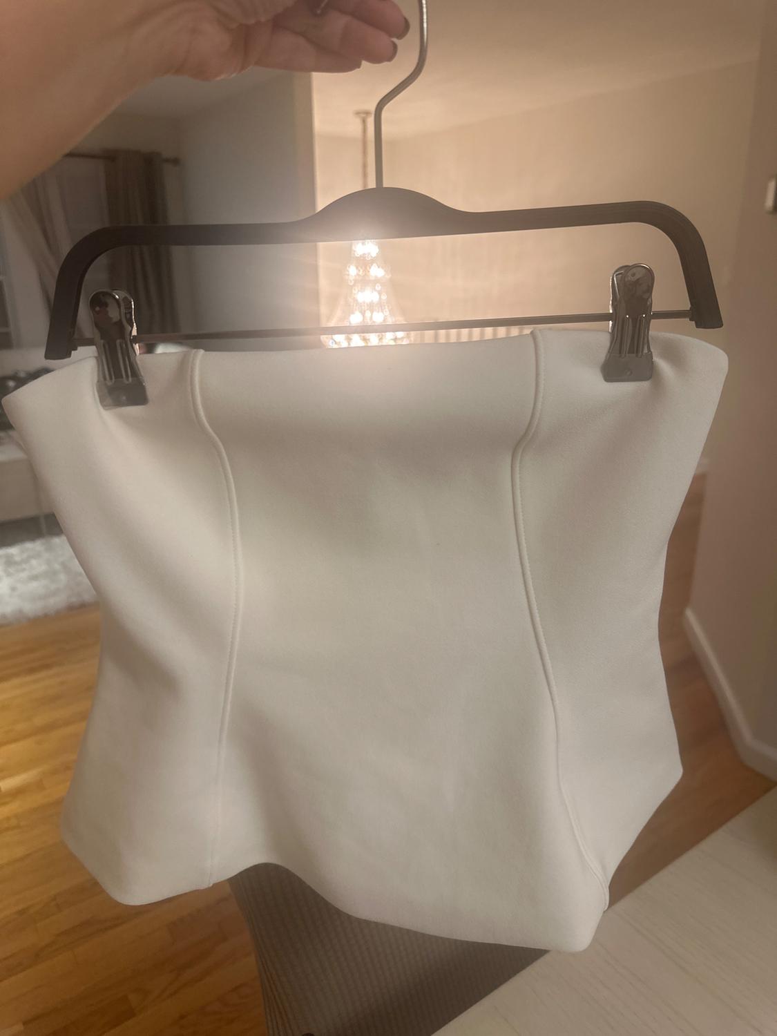 Front view of a white strapless top on a hanger