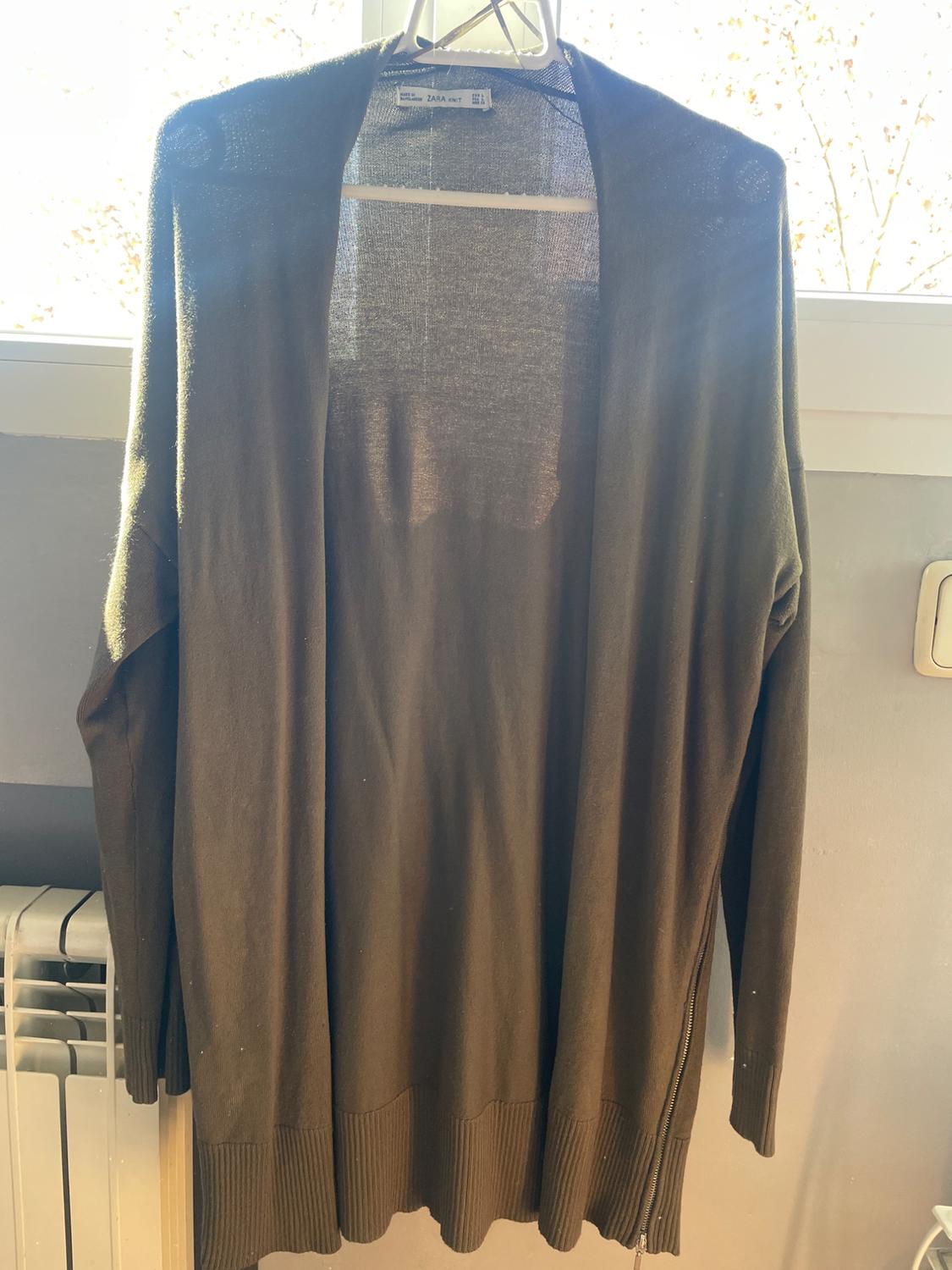 Front view of a long olive green cardigan with long sleeves and a ribbed hem.