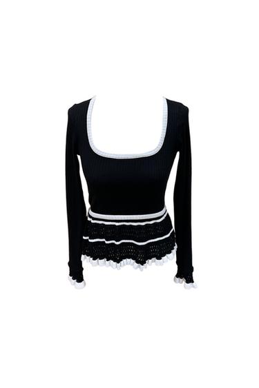 Black long-sleeved top with a square neckline and white trims. Cuffs and hem with openwork knitted frills and contrasting edges.
