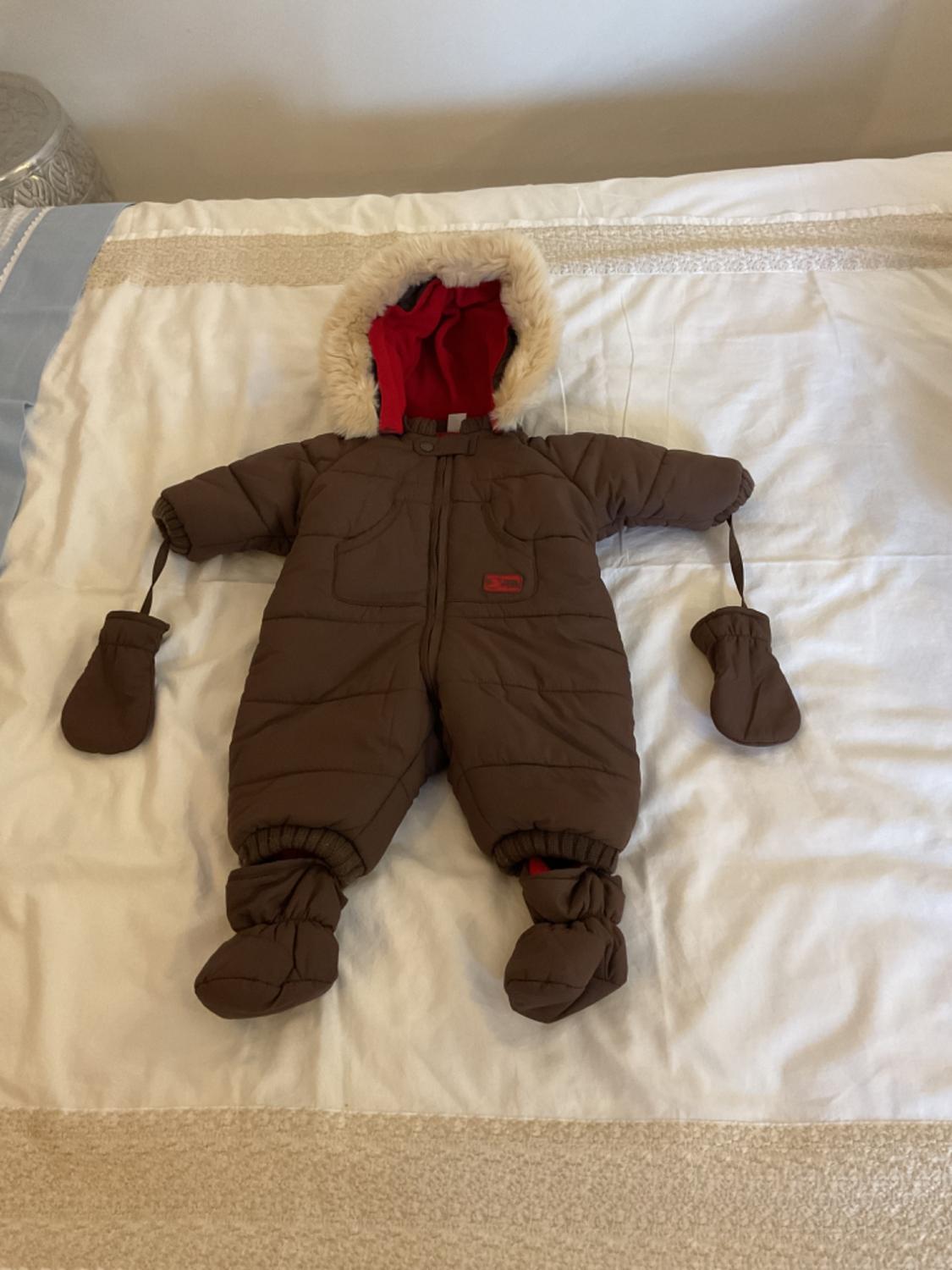 Front view of a brown monkey with a fur hood, mittens and covered feet.