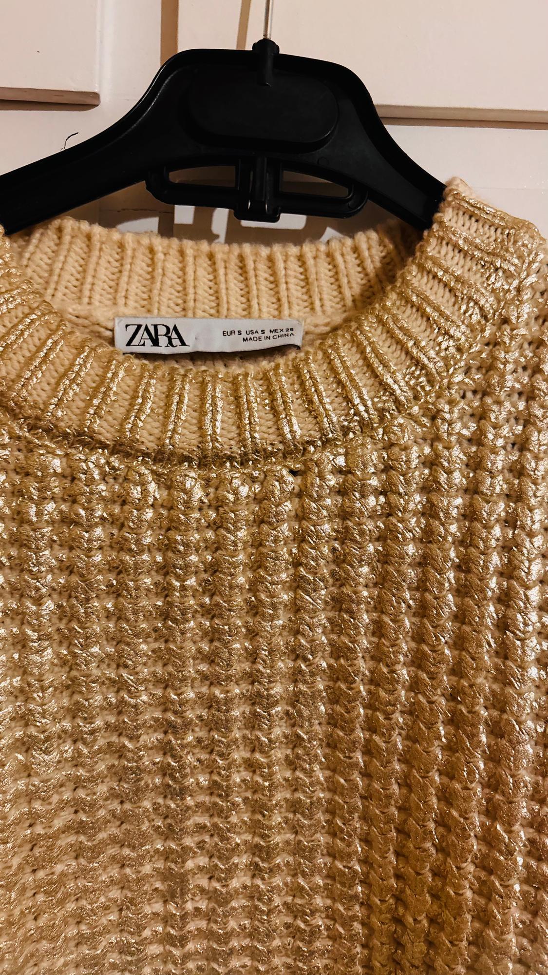 Textured gold jumper hanging on a black hanger. Visible label with Zara brand and size EUR S USA S MEX 26.