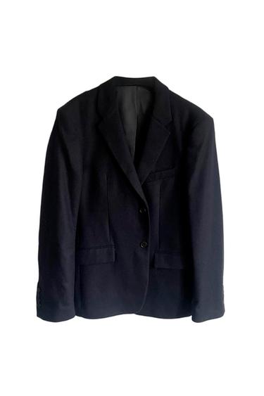 Black suit jacket with classic lapels and two buttons, hanging against a white background.
