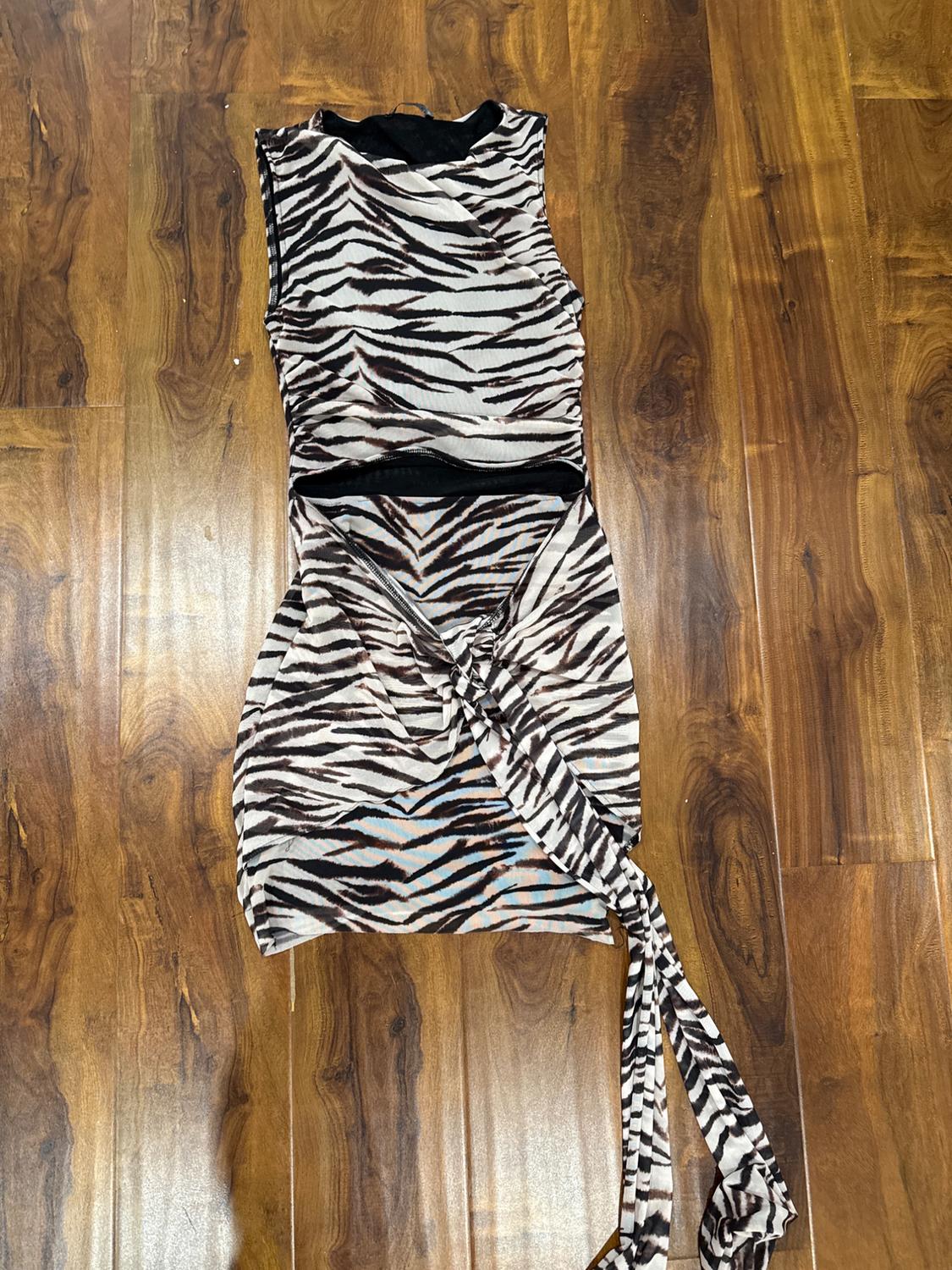 Sleeveless dress with brown and black zebra stripe print, on a wooden floor.