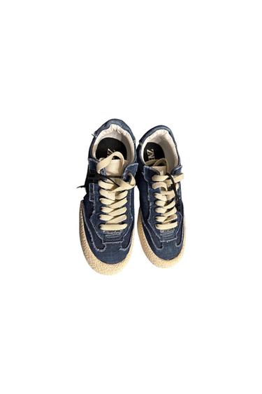 Blue canvas sneakers with beige laces and a textured sole. Visible white interior. "ZARA" text on the insole. White background.