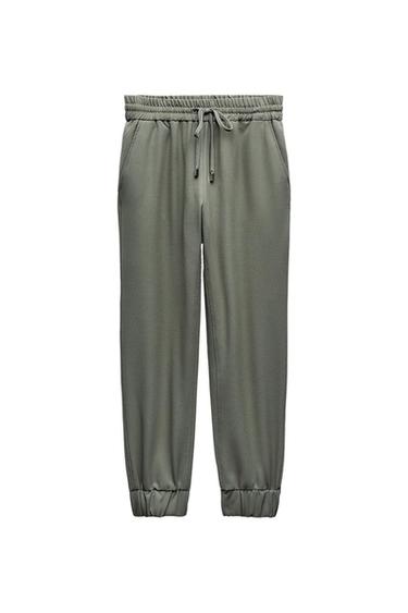 Olive green joggers with an elasticated waist, adjustable drawstring, pockets, and elasticated cuffs on a white background.