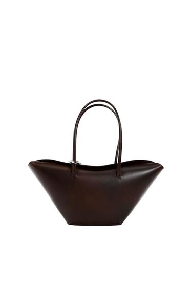 Dark brown handbag with long handles and a spacious design, on a white background.