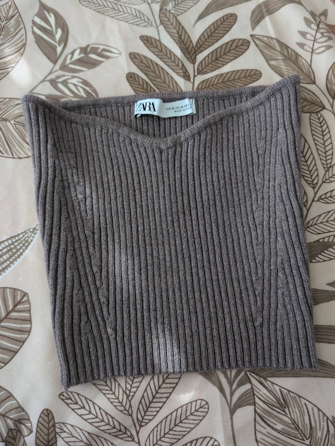 Brown ribbed knit top over leaf-print fabric. Text: ZARA EUR M USA M MEX 28 MADE IN CHINA.
