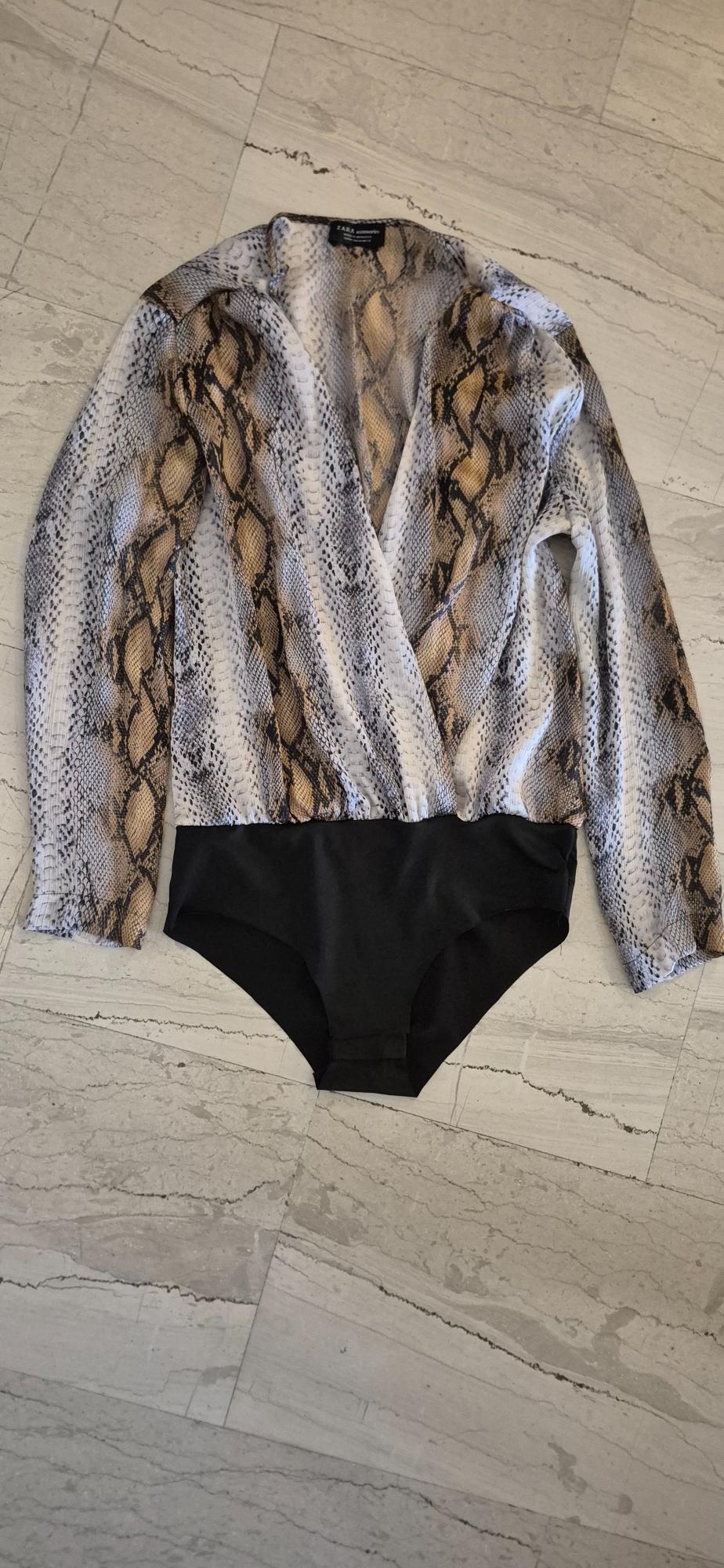 Black bodysuit with brown and white snake print, on a light marble floor. Visible label: Zara.