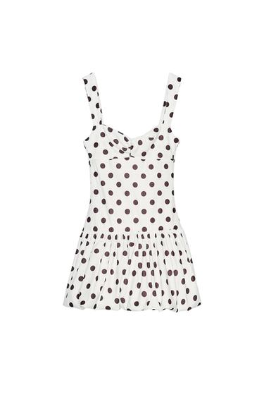 Front view of a white dress with black polka dots and thick straps.