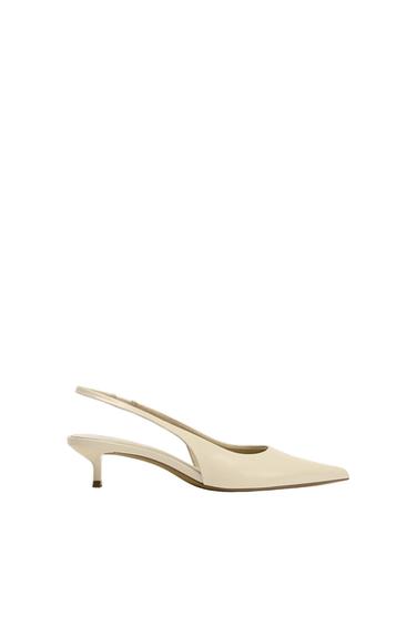 Cream low-heeled shoe with a pointed toe and slingback design, on a white background.