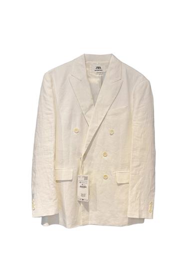 White cross-over blazer with light buttons and a hanging label on a white background. Inside label with the text ZARA MAN SARTORIAL.
