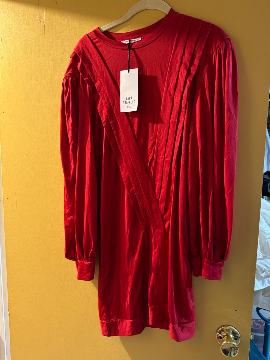 Front view of a red pleated dress with a visible 'Zara Trafaluc' label.