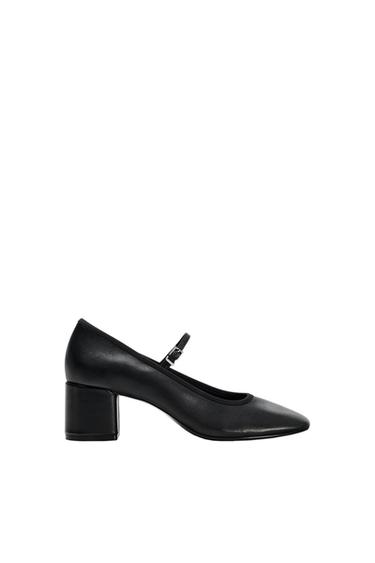 Black mid-heel, round-toe shoe with an adjustable strap, on a white background.