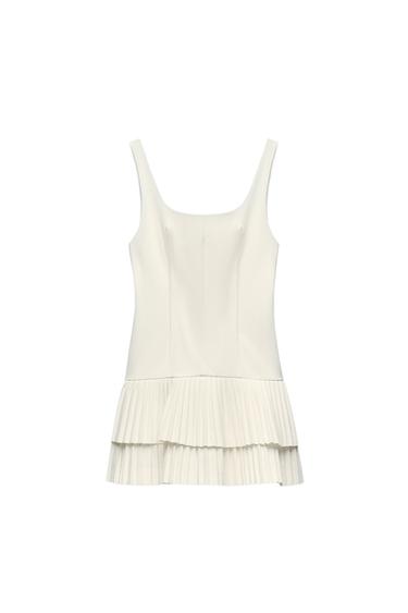 Front view of a white dress with wide straps and a pleated skirt.