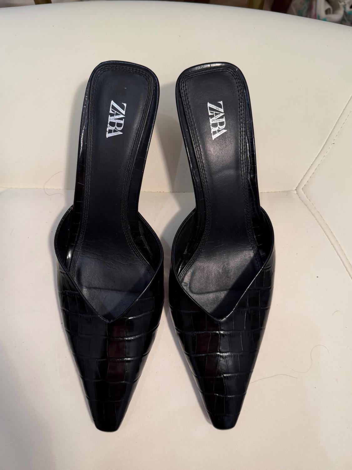 Black slingback shoes with a crocodile texture and a pointed toe on a white surface. The insoles feature the text ZARA.