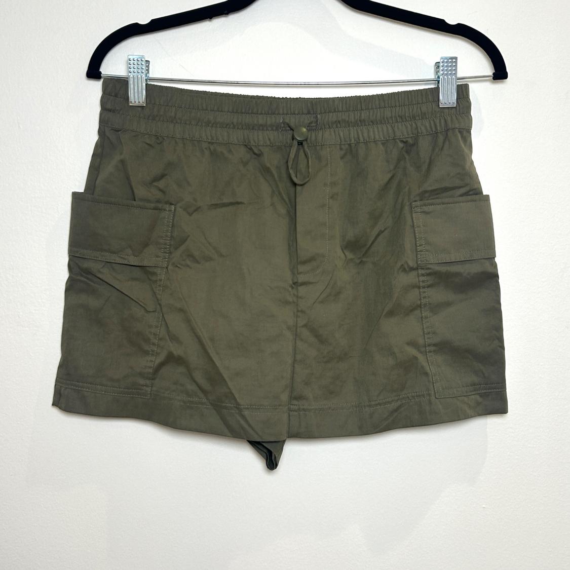 Front view of olive green shorts with side flap pockets and elastic waistband.