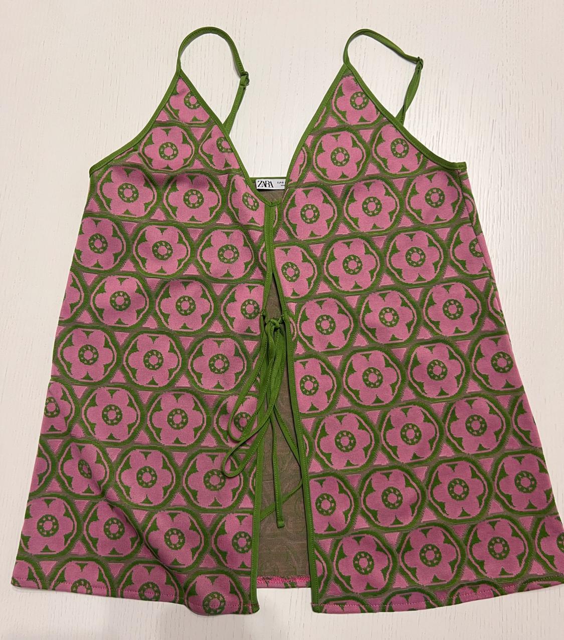 Sleeveless top with geometric print in pink and green, thin straps and front tie. Visible "ZARA" label.