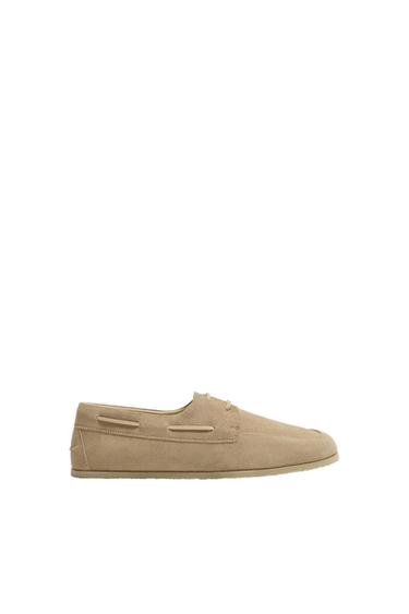Beige suede lace-up shoe on a white background.