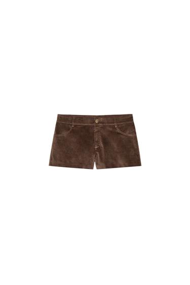 Front view of brown mini shorts with front and back patch pockets. Front zip and button fastening.