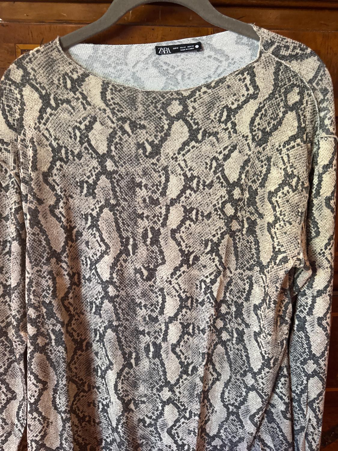 Grey and beige snake print jumper, hanging on a wooden hanger. Visible tag: ZARA.