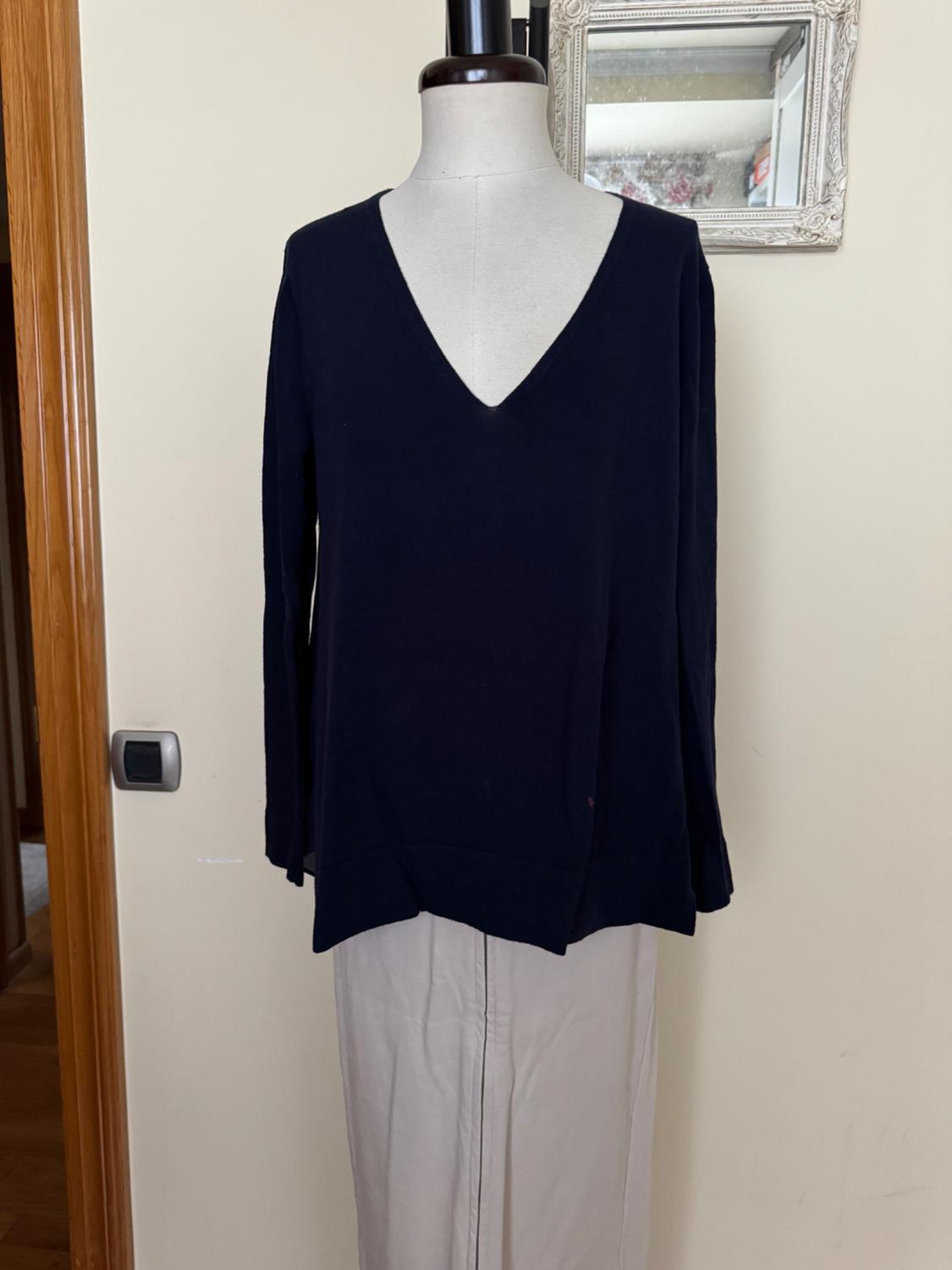 Front view of black V-neck sweater on a mannequin.