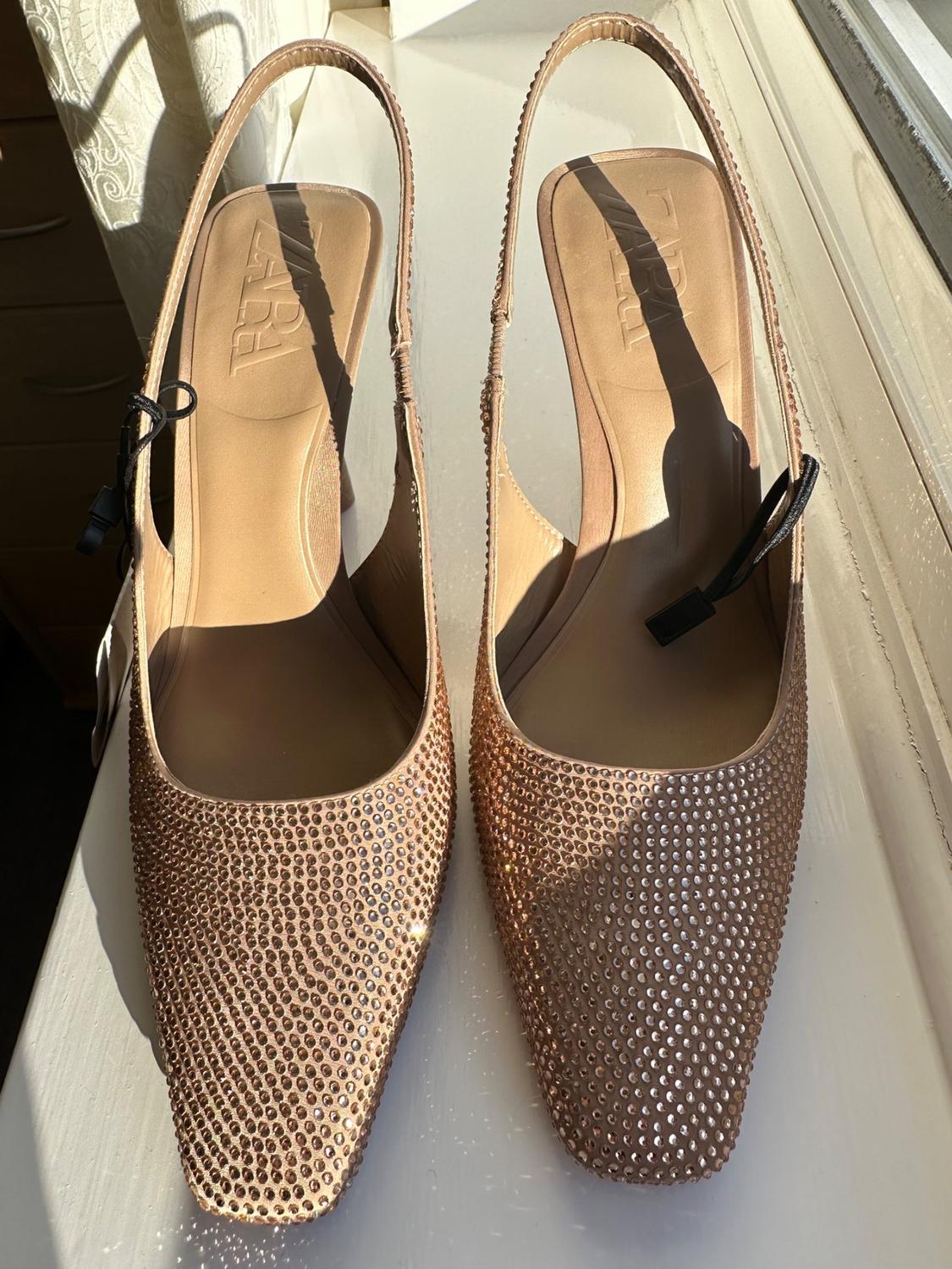 Front view of strappy shoes with sparkling embellishments in nude