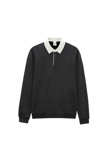 Dark grey jumper with white collar and button fastening. White background. Visible label on the collar.