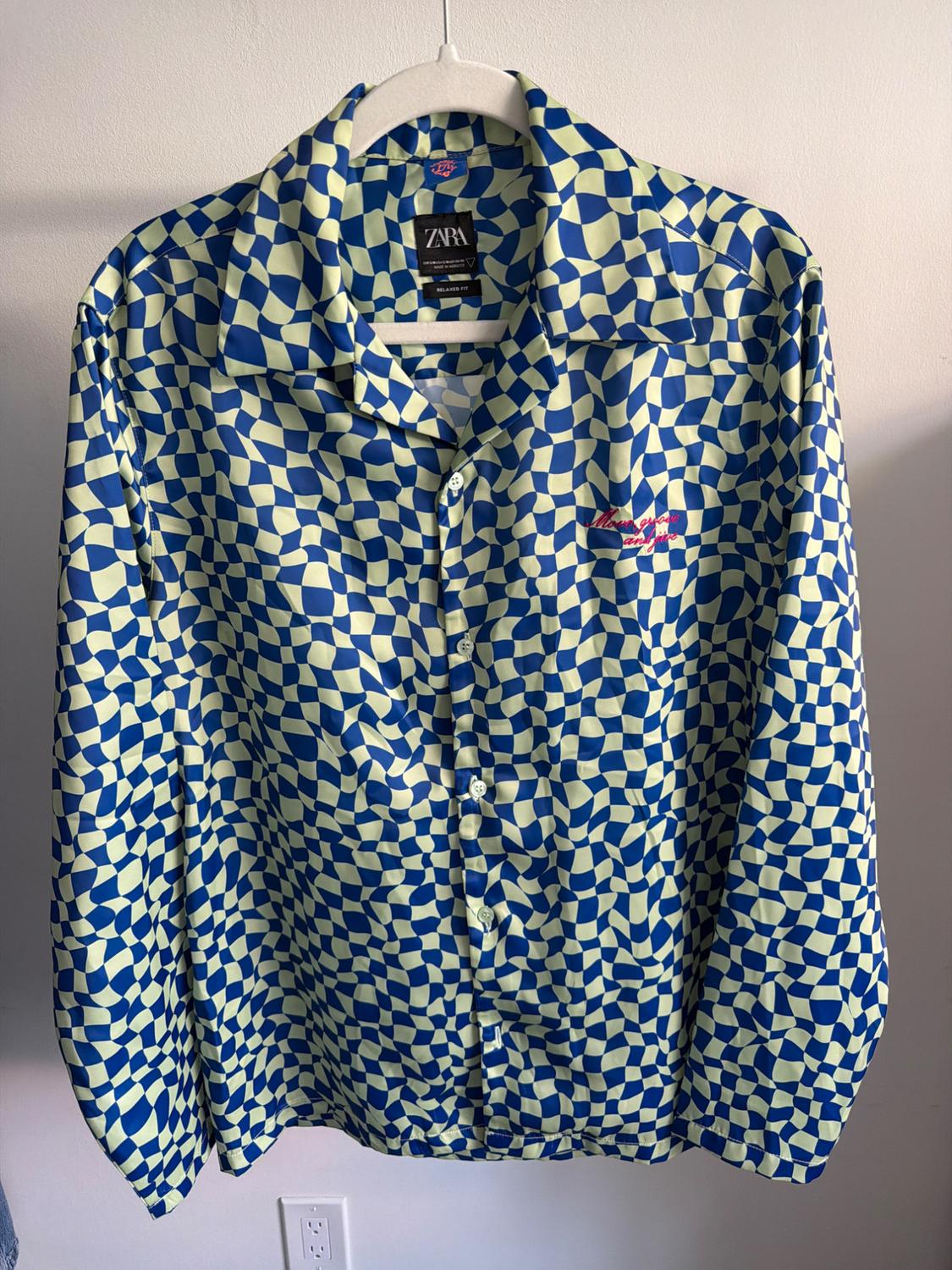 Blue and yellow geometric print shirt, hanging. Visible text: "ZARA" on the label and "Miami Vice" embroidered in red.