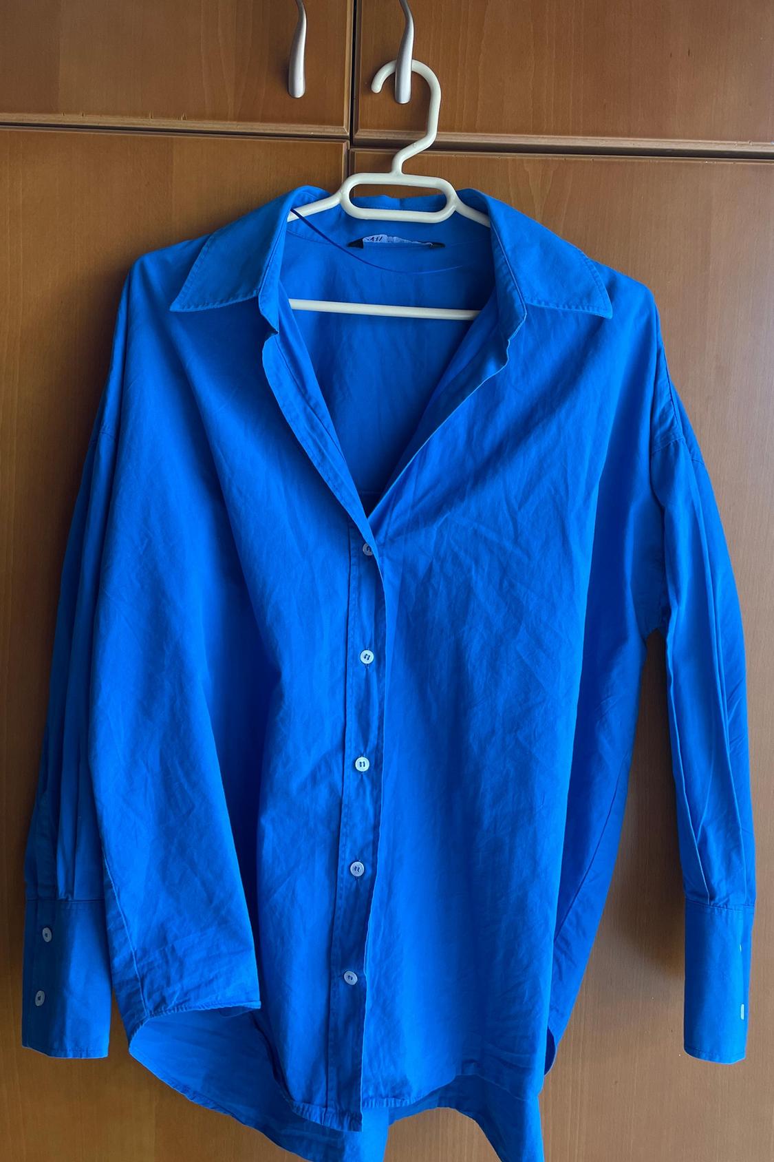 Front view of blue shirt with buttons and classic collar.