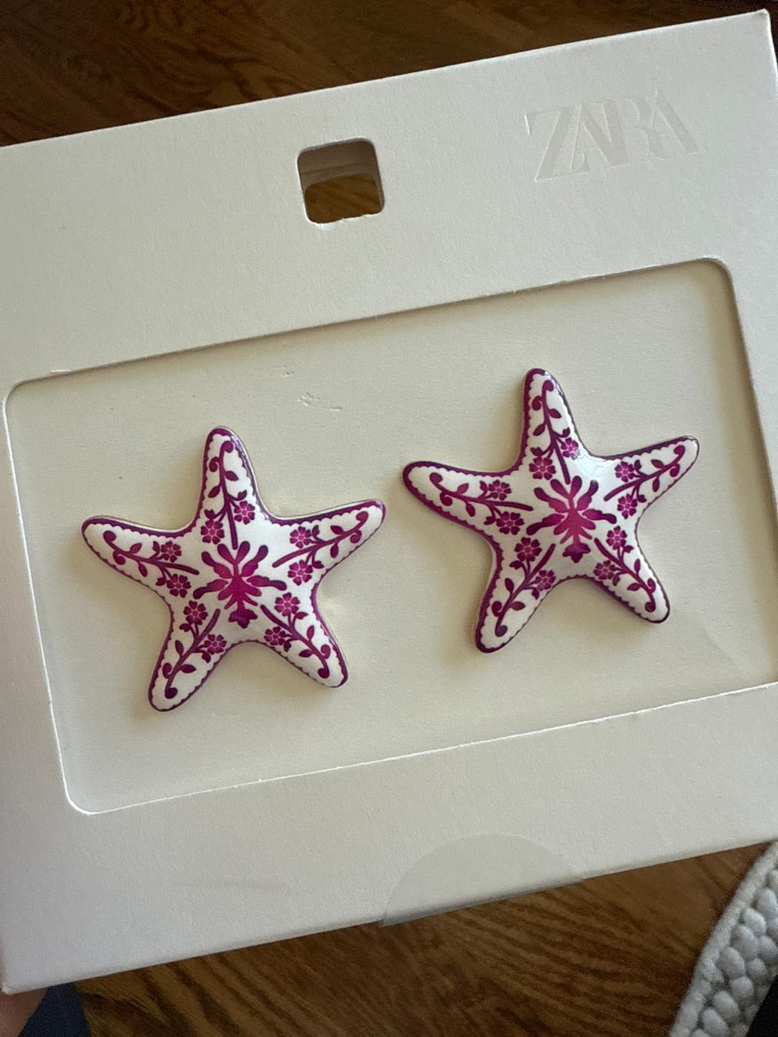 White box with two starfish-shaped ornaments, decorated with purple floral patterns. Visible text: "ZARA".