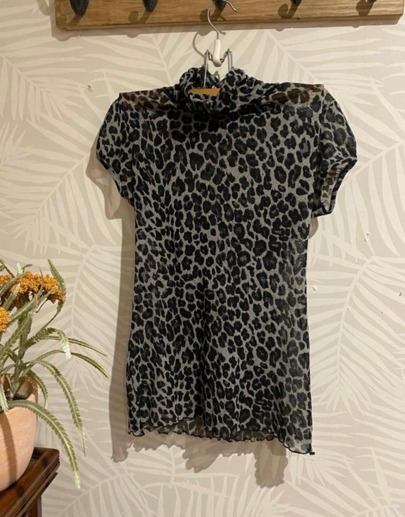 Front view of a dark-toned, high-necked dress with a leopard print.