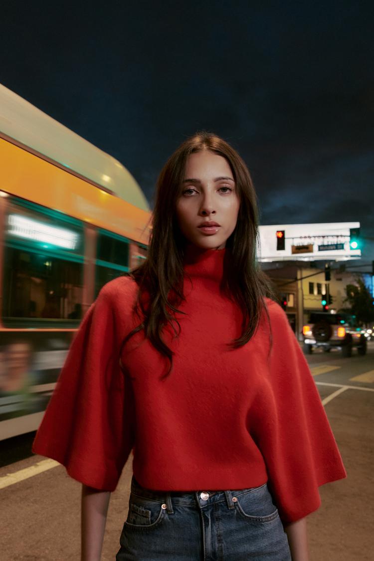 Sada �erven�ho pleten�ho svetru s rol�kem a �irok�mi t���tvrte�n�mi ruk�vy, kombinovan� s modr�mi d��ny.