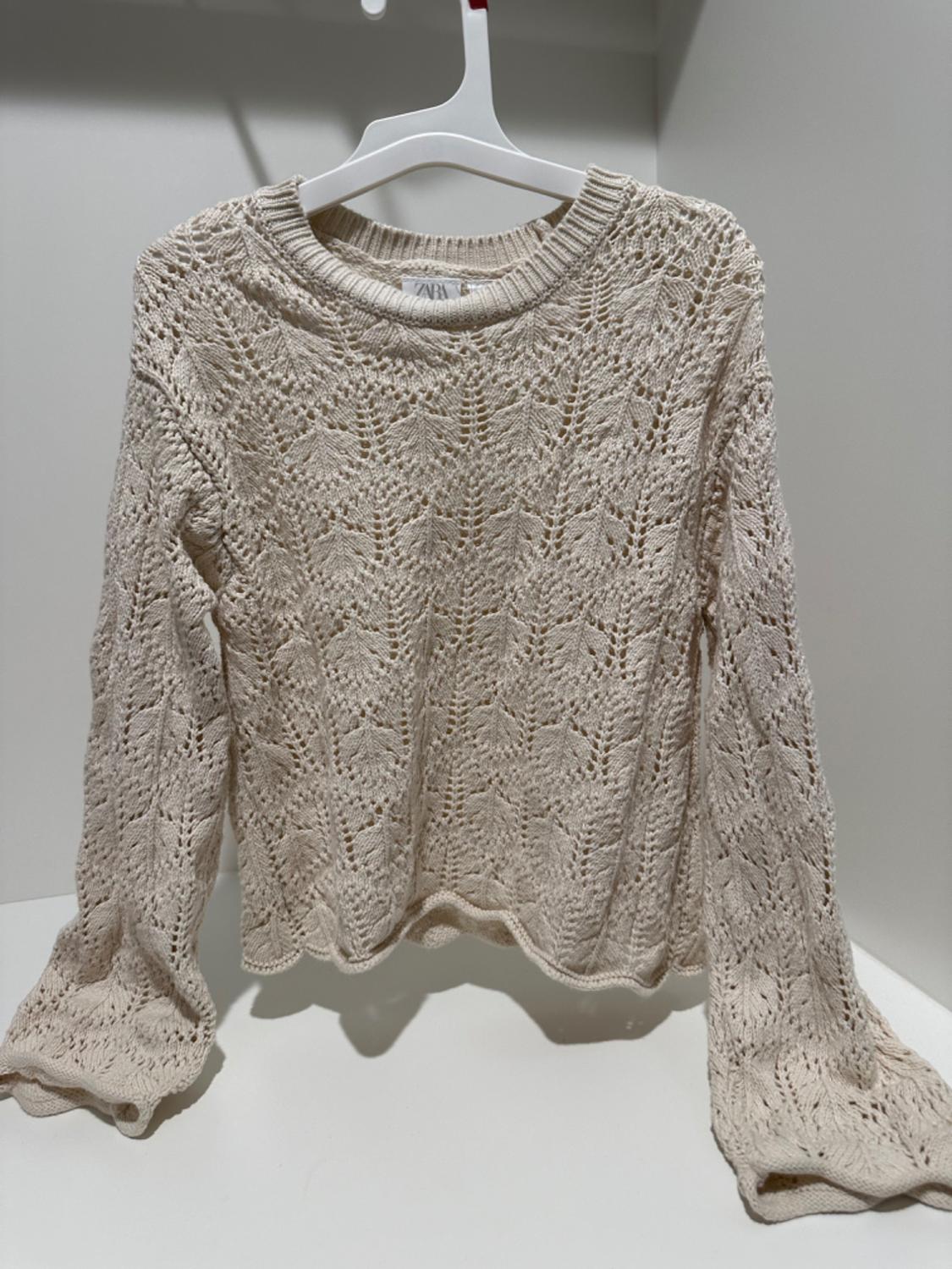 Front view of beige jumper with openwork pattern and crew neck.
